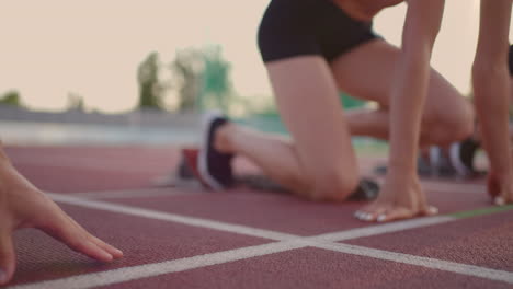 Primer-Plano,-Tres-Atletas-Femeninas-De-Pista-Y-Agua-En-La-Línea-De-Salida-De-La-Competición-Del-Estadio-Se-Preparan-Y-Huyen-En-Una-Carrera-De-Sprint.